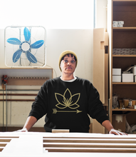 Load image into Gallery viewer, Black woman in factory wearing Black unisex crew neck with Lotus Noir logo in center

